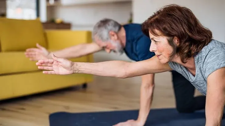 Two people training together in one room, both mid-movement